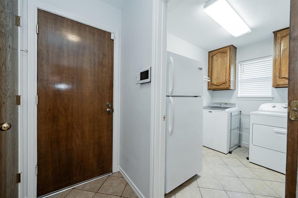 8304 Navigation Drive Rowlett, TX 75088 - Photo 21 of 40 Laundry area with light tile patterned floors and washing machine and clothes dryer