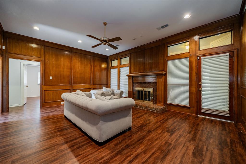 8304 Navigation Drive Rowlett, TX 75088 - Photo 22 of 40 Living area with wooden walls, a brick fireplace, a ceiling fan, dark wood-style flooring, and recessed lighting