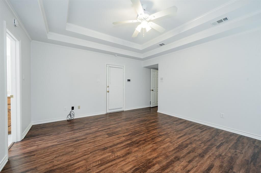 8304 Navigation Drive Rowlett, TX 75088 - Photo 26 of 40 Unfurnished room featuring a raised ceiling, dark wood-style floors, ornamental molding, and ceiling fan
