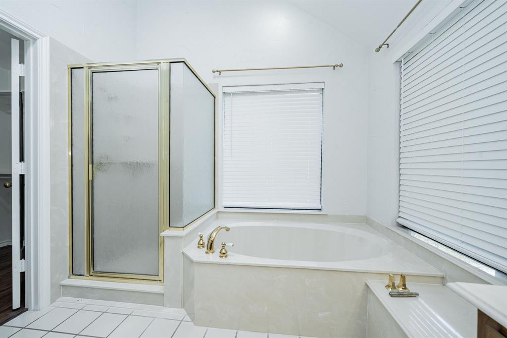 8304 Navigation Drive Rowlett, TX 75088 - Photo 28 of 40 Full bath with a shower stall, a bath, tile patterned flooring, a closet, and vaulted ceiling
