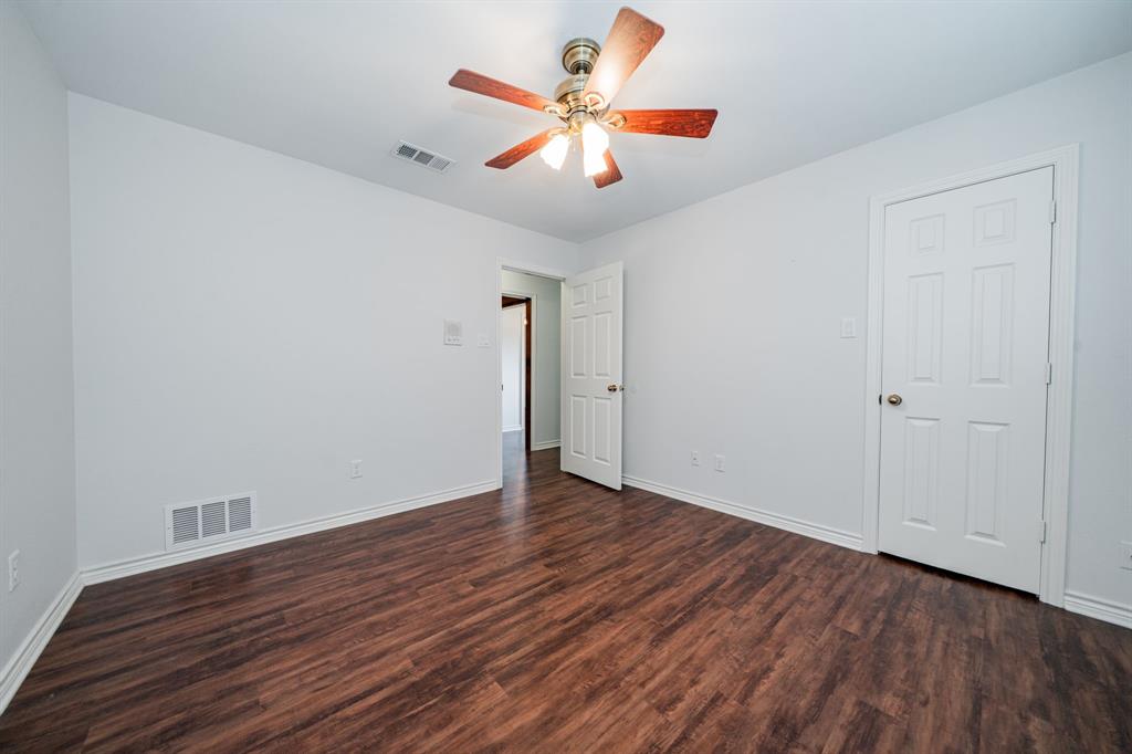 8304 Navigation Drive Rowlett, TX 75088 - Photo 31 of 40 Unfurnished bedroom with dark wood-style floors and a ceiling fan