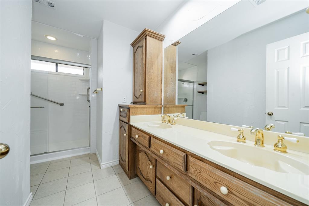 8304 Navigation Drive Rowlett, TX 75088 - Photo 32 of 40 Full bathroom with double vanity, light tile patterned floors, and a shower stall