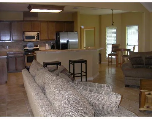 a living room with stainless steel appliances kitchen island granite countertop furniture and a view of kitchen