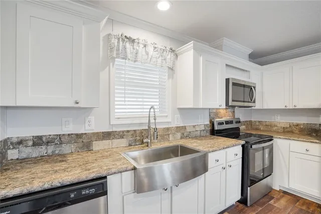 a kitchen with granite countertop a sink a stove and cabinets