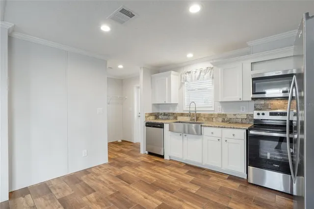 a kitchen with granite countertop a sink and stainless steel appliances