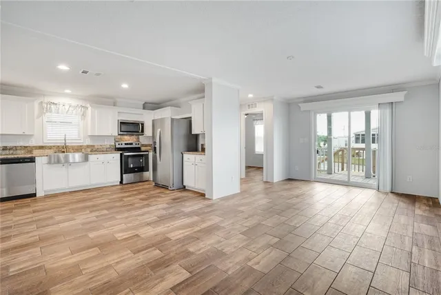 a view of kitchen with granite countertop cabinets and refrigerator