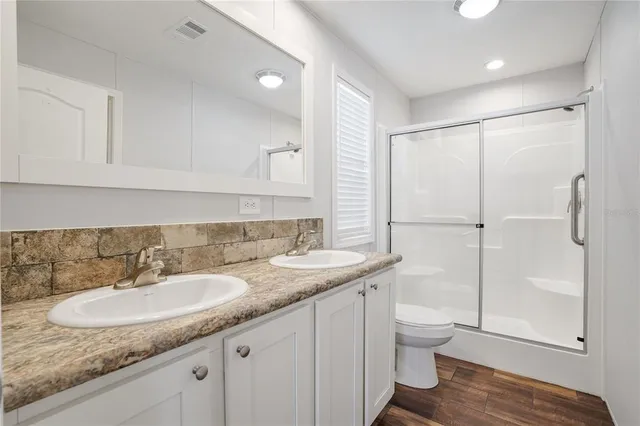 a bathroom with a granite countertop sink toilet and shower