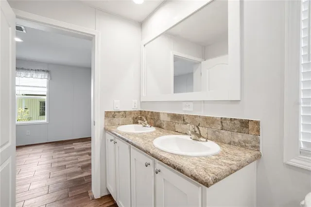 a bathroom with a granite countertop sink and a mirror