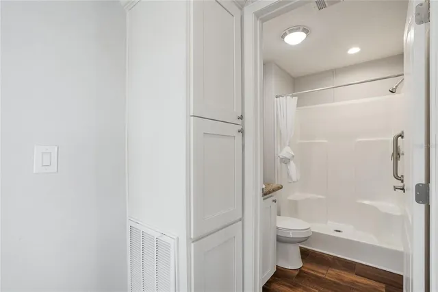a bathroom with a granite countertop toilet a sink and shower