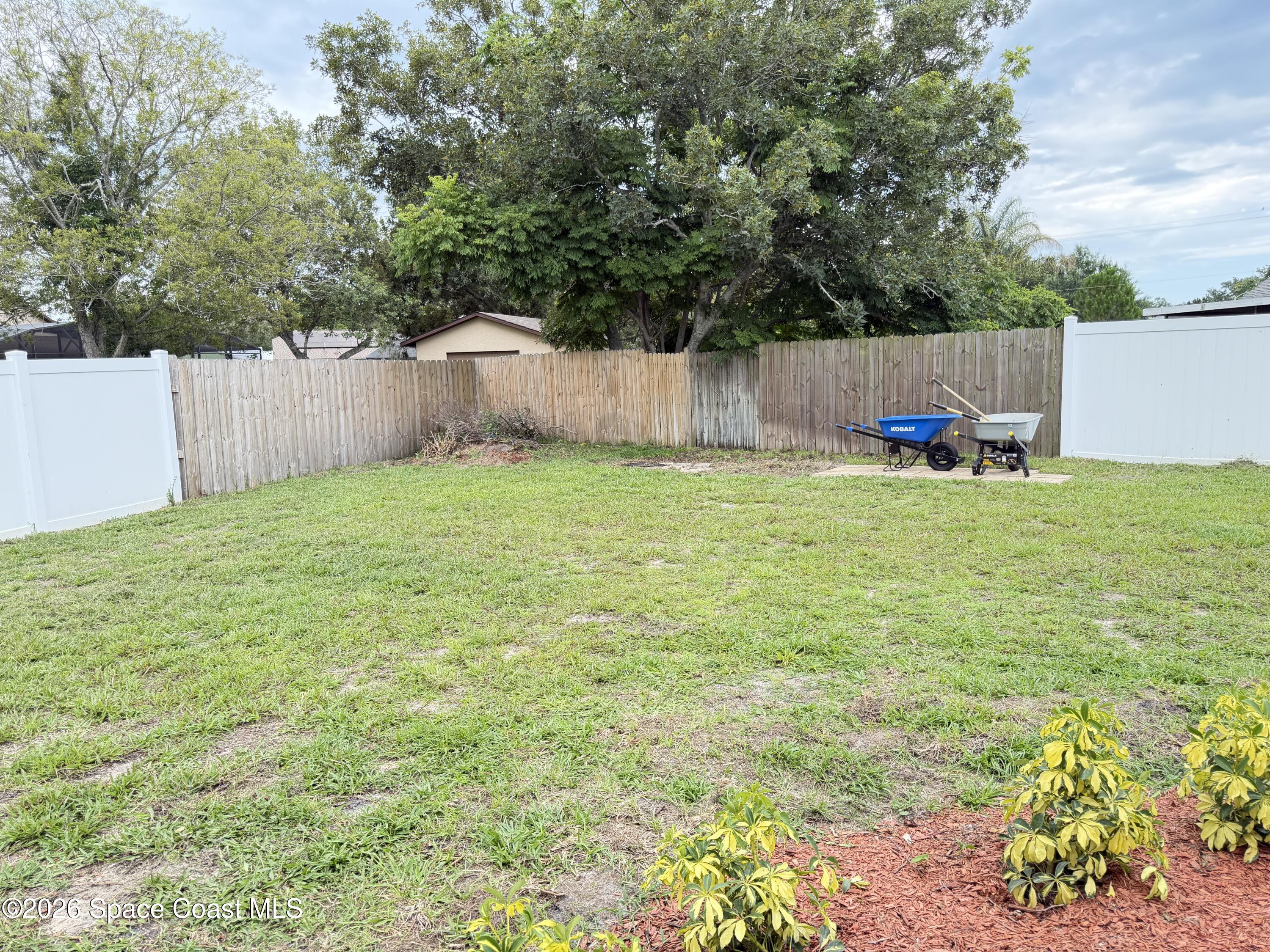 1578 West Powder Horn Road Titusville, FL 32796 - Photo 20 of 22 a backyard of a house with a small yard and wooden fence