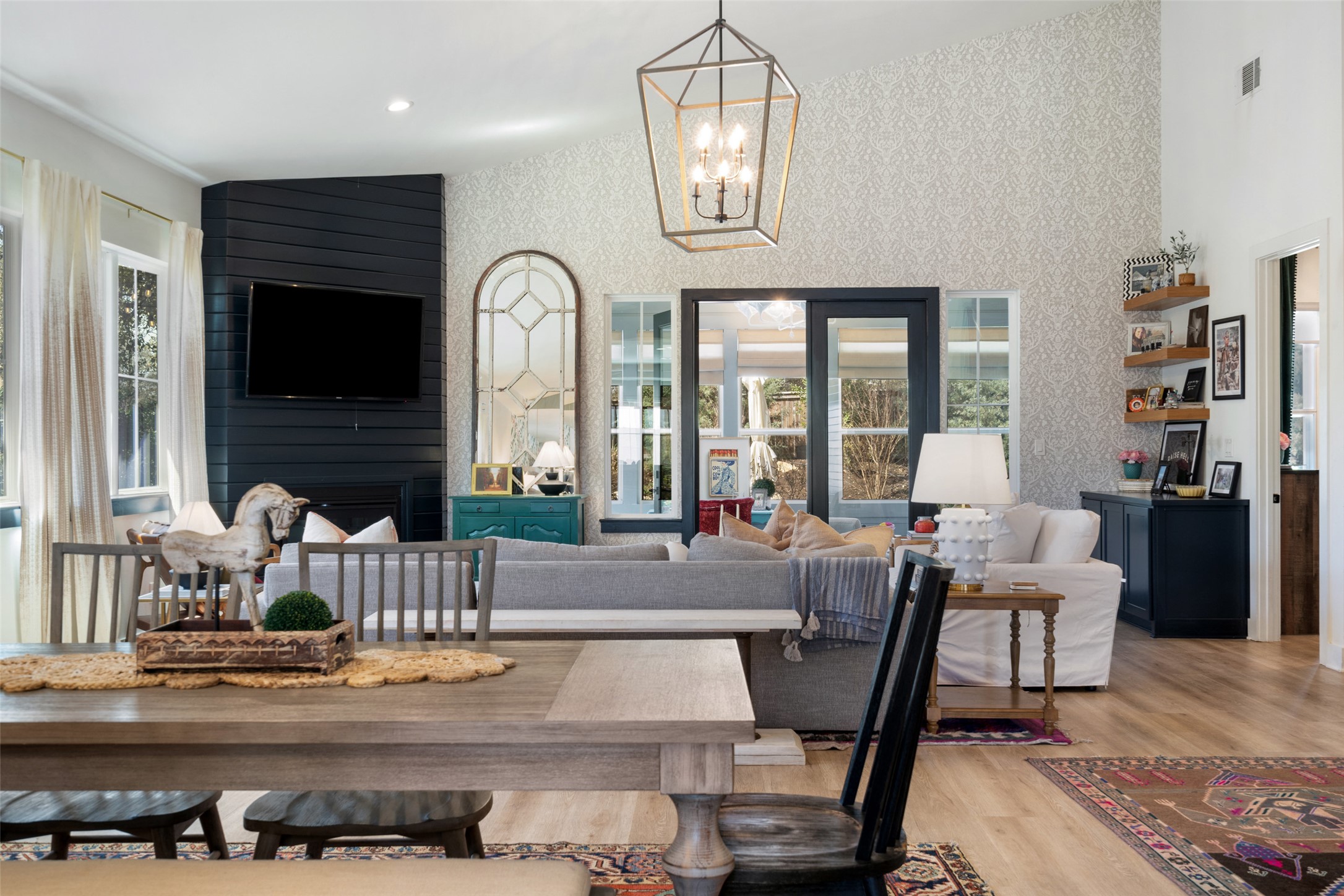 170 Bunker Rnch Boulevard, Unit 28 Dripping Springs, TX 78620 - Photo 9 of 37 Dining room featuring wallpapered walls, light wood finished floors, an accent wall, a fireplace, and hanging lights