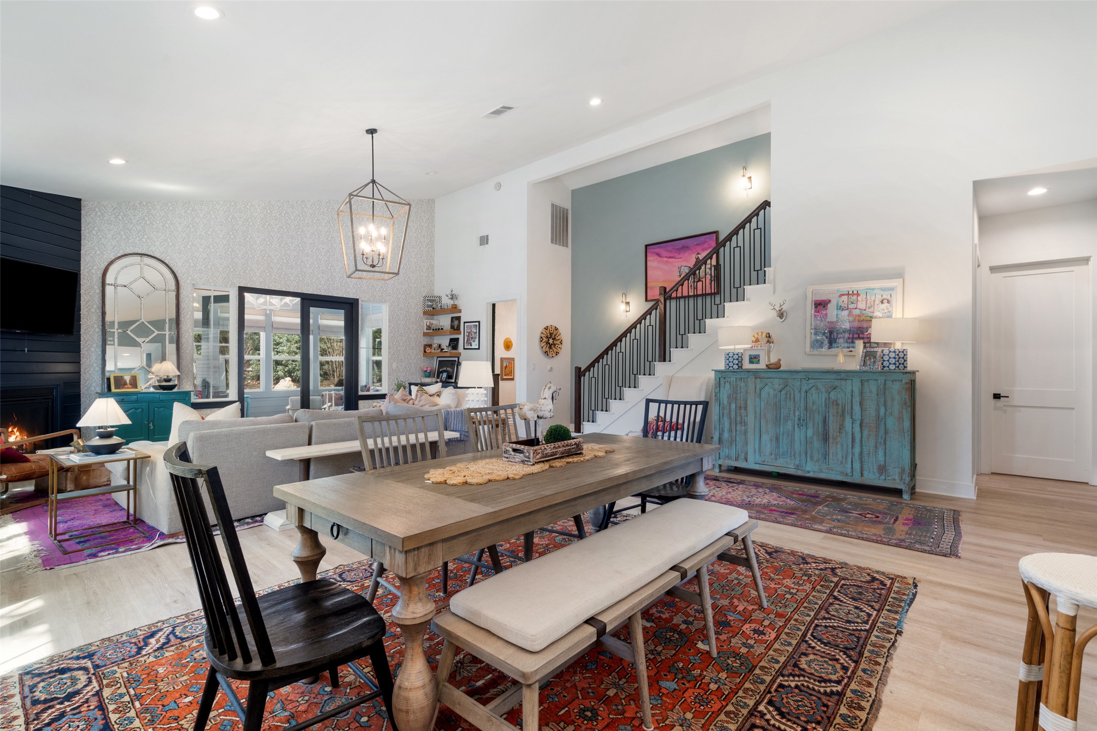 170 Bunker Rnch Boulevard, Unit 28 Dripping Springs, TX 78620 - Photo 13 of 37 Dining area with light wood-style flooring, a fireplace, a high ceiling, and a chandelier
