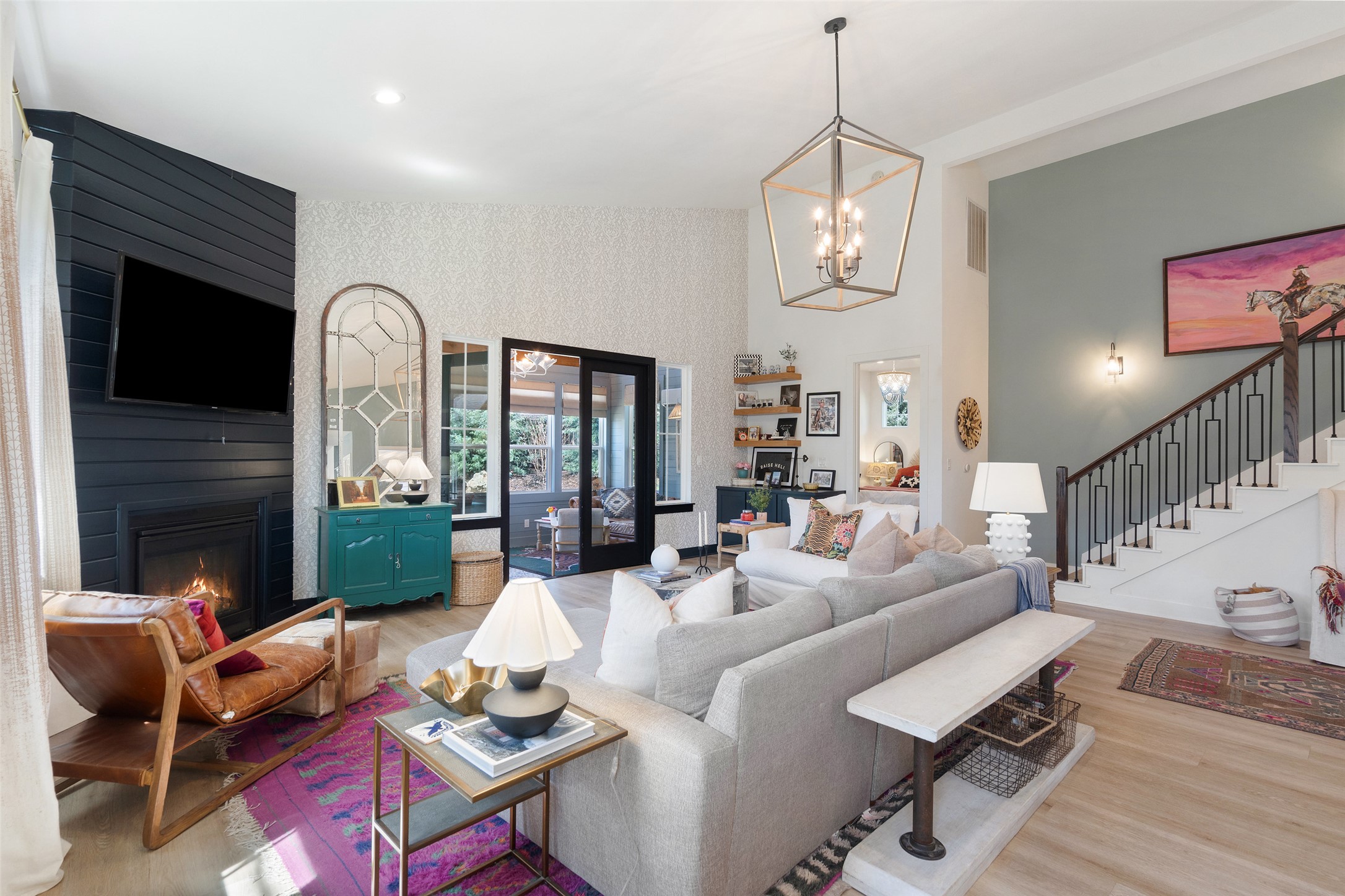 170 Bunker Rnch Boulevard, Unit 28 Dripping Springs, TX 78620 - Photo 14 of 37 Living room featuring a fireplace, wood finished floors, a high ceiling, and wallpapered walls