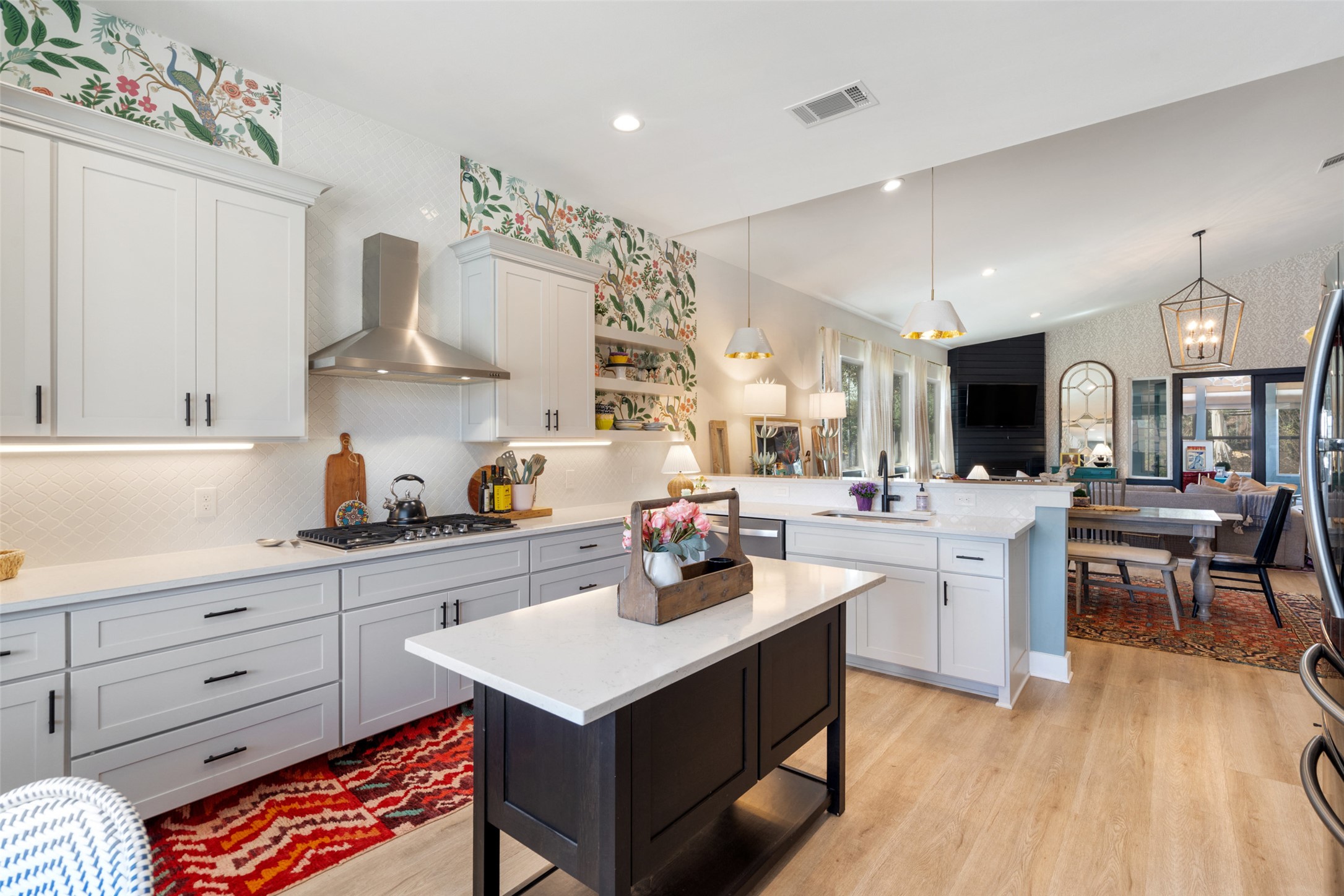 170 Bunker Rnch Boulevard, Unit 28 Dripping Springs, TX 78620 - Photo 37 of 37 Two tone kitchen featuring wallpapered walls, a peninsula, lofted ceiling, open floor plan, and light wood-style floors