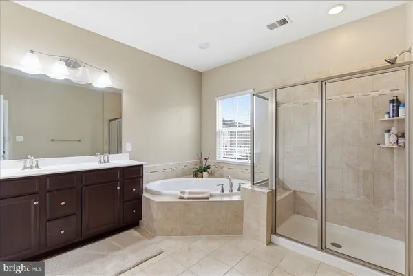 a bathroom with a tub sink shower and mirror