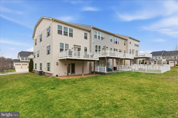 a large white building with a big yard and large trees