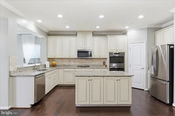 a kitchen with white cabinets sink and stainless steel appliances