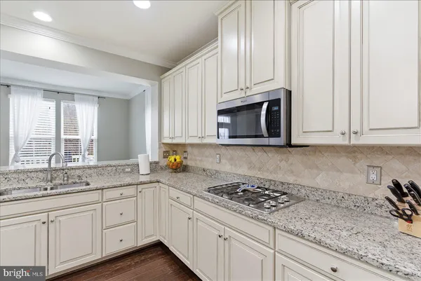 a kitchen with granite countertop a sink stove and cabinets