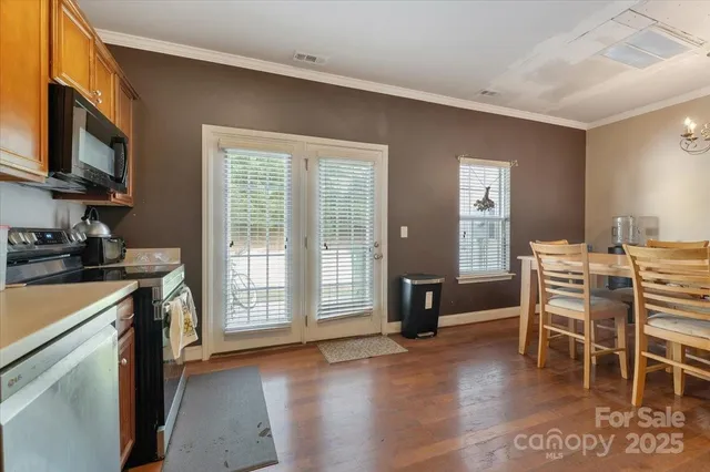 a kitchen that has a stove a table and chairs in it