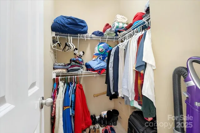 a view of walk in closet with clothes and shoes