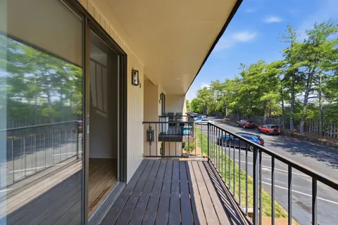 a view of balcony with wooden floor and fence