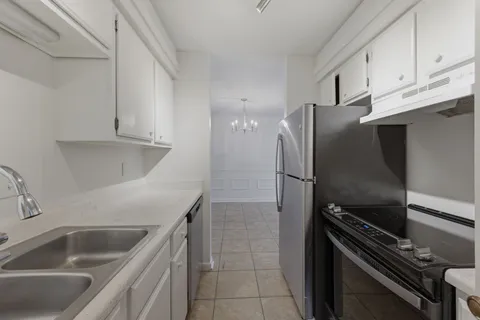 a kitchen with a refrigerator sink and cabinets