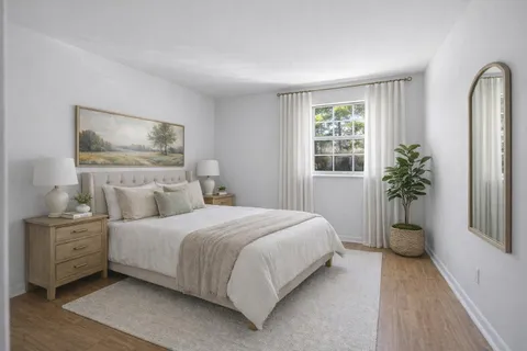 a bedroom with a large bed and a potted plant