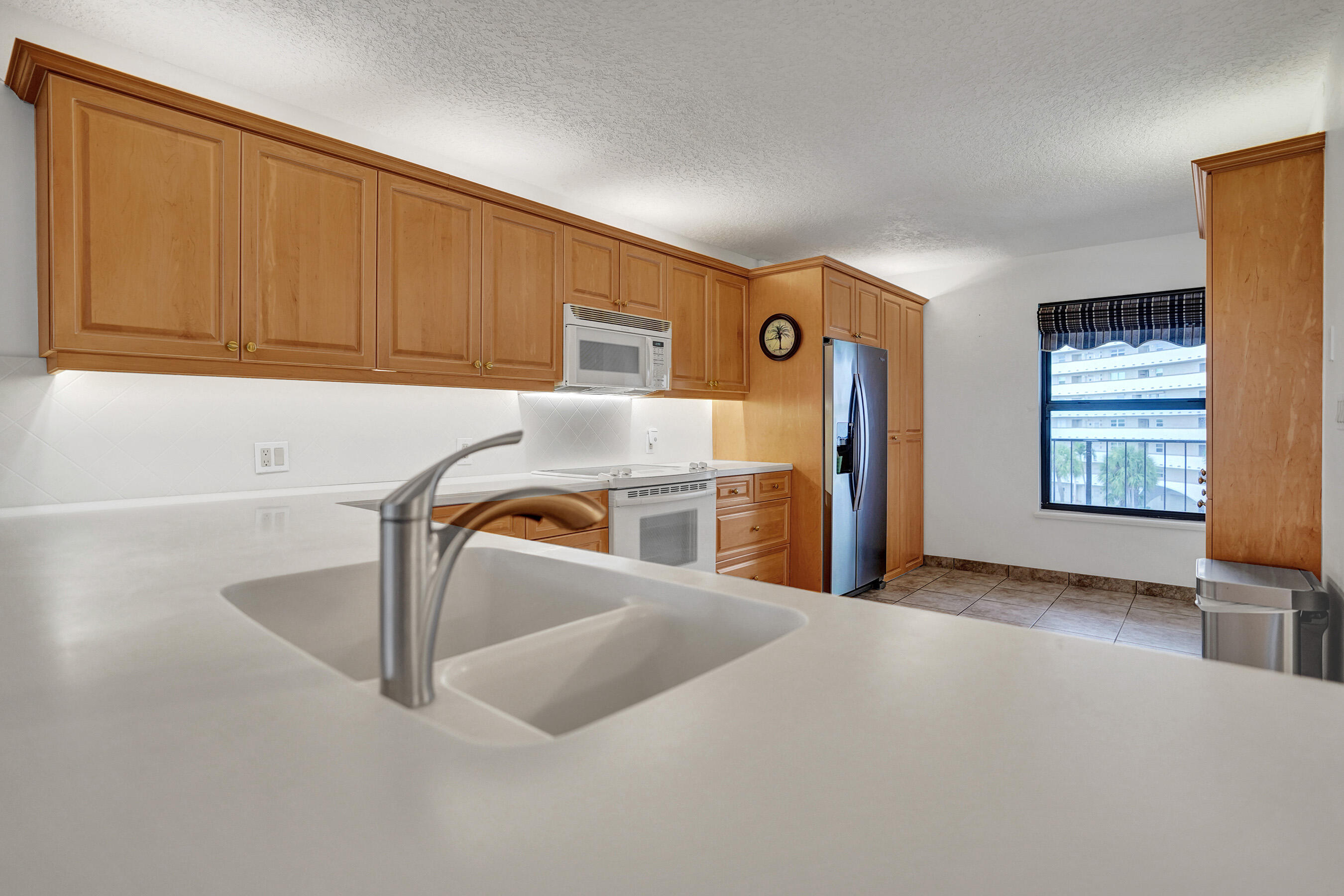 1627 Riverview Road, Unit 410 Deerfield Beach, FL 33441 - Photo 12 of 56 a kitchen with stainless steel appliances granite countertop a sink and a refrigerator