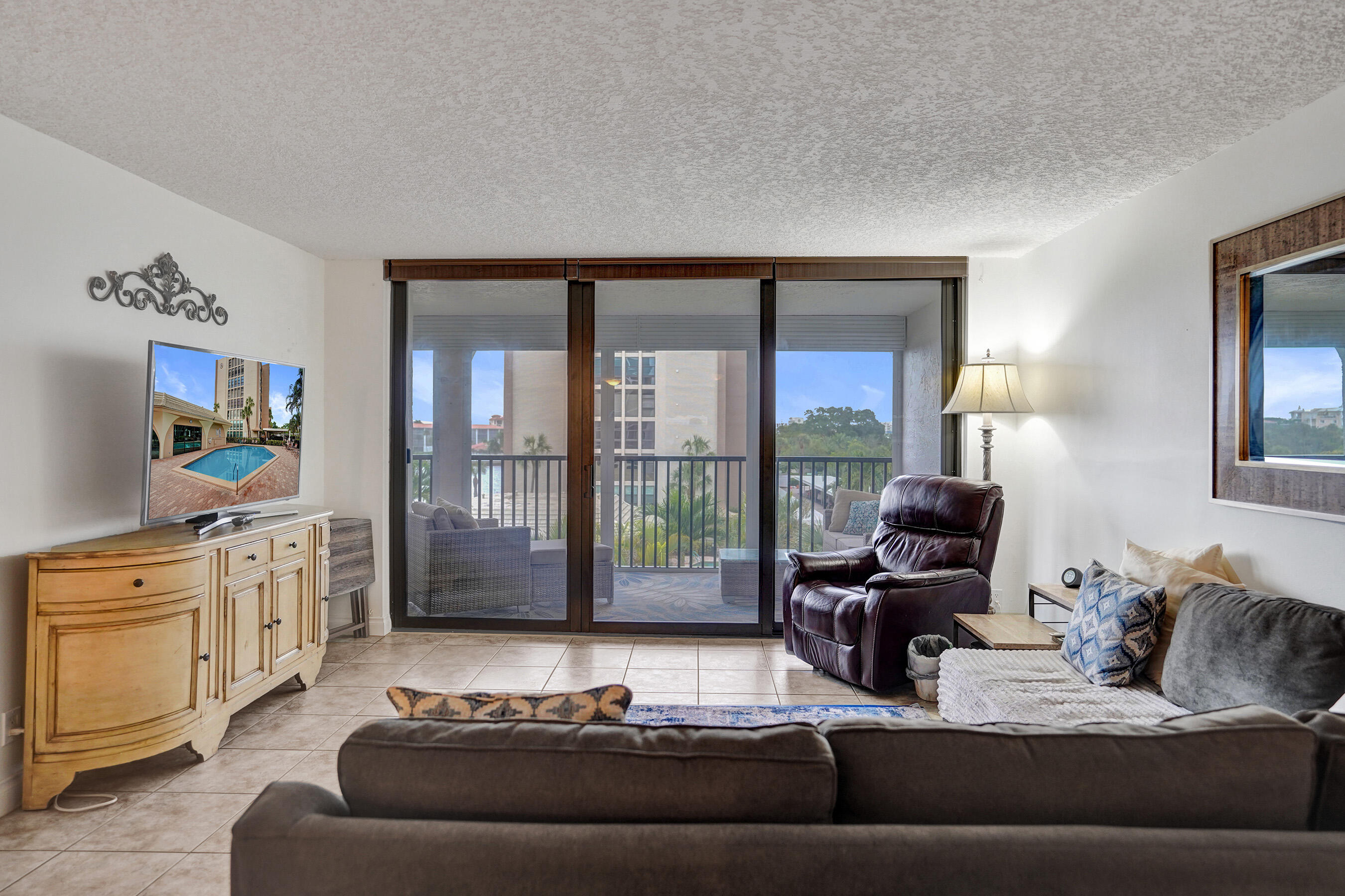 1627 Riverview Road, Unit 410 Deerfield Beach, FL 33441 - Photo 29 of 56 a living room with furniture and a flat screen tv