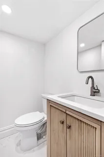 a bathroom with a toilet a sink and mirror
