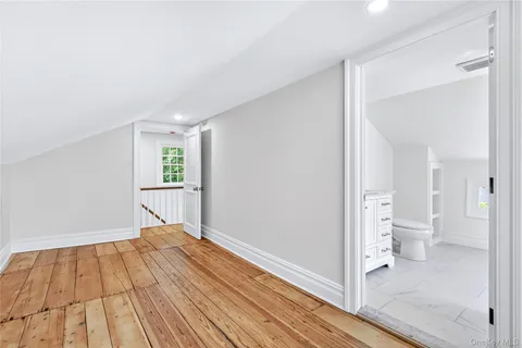 a view of a room with wooden floor and a bathroom