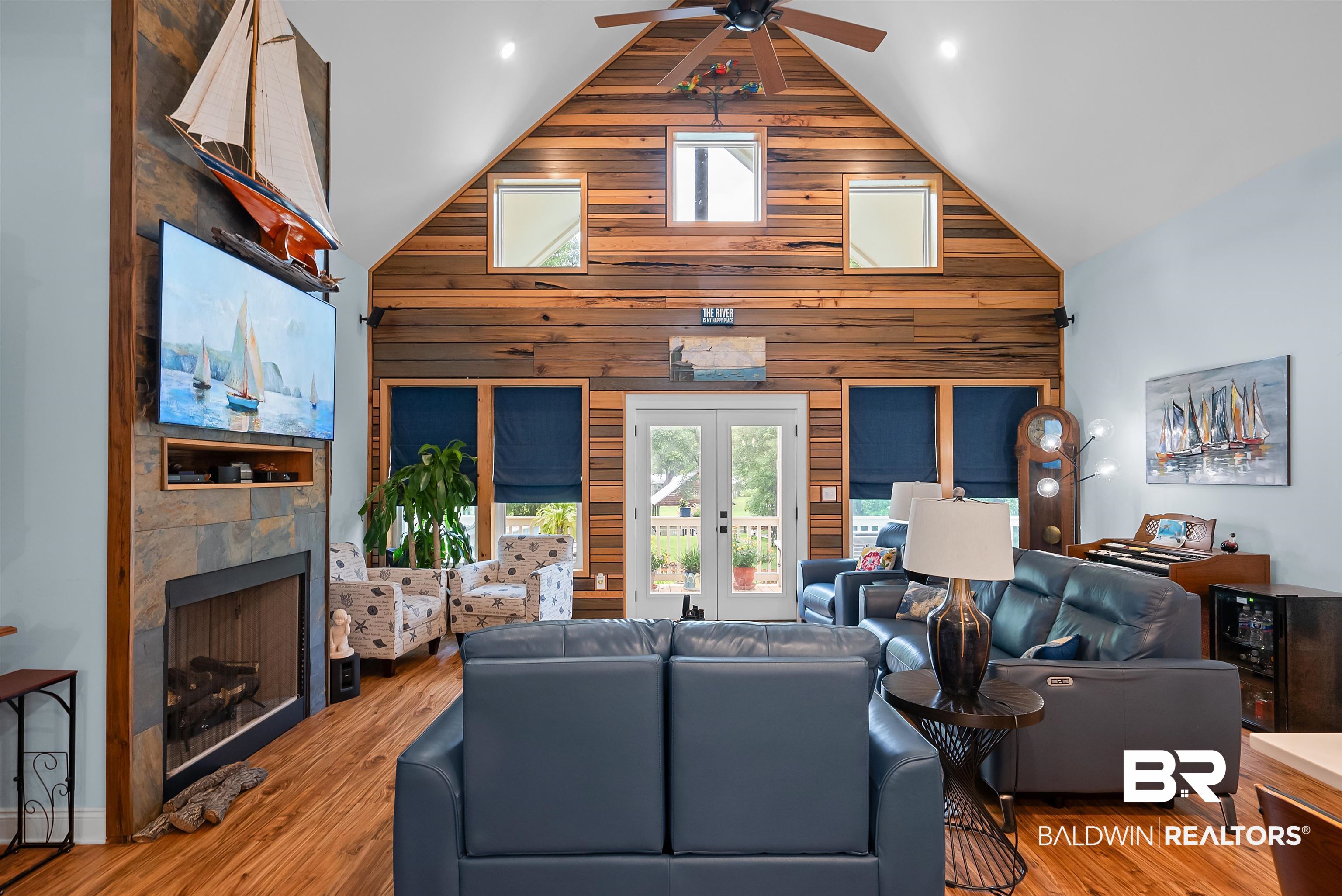 7266 Franklin Road Foley, AL 36535 - Photo 16 of 64 Vaulted ceiling living area featuring a wood plank accent wall, a ceiling fan, and hardwood flooring