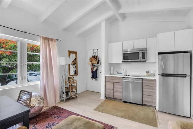 a kitchen with a refrigerator and a stove top oven