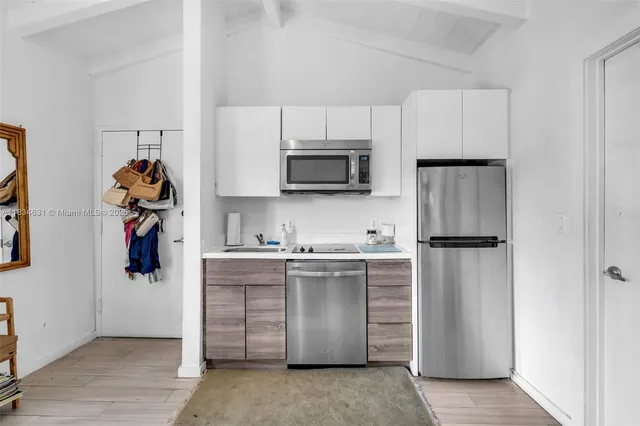 a kitchen with stainless steel appliances granite countertop a refrigerator and a stove top oven