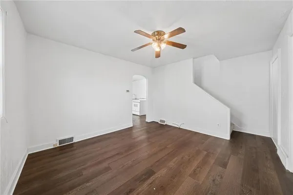 a view of empty room with wooden floor