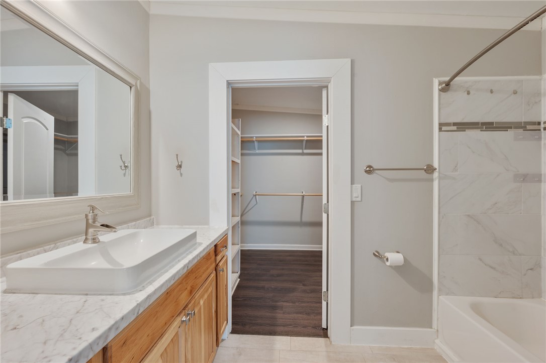 11688 Long Trussel Road Bryan, TX 77808 - Photo 11 of 29 a bathroom with a double vanity sink a mirror and a bathtub