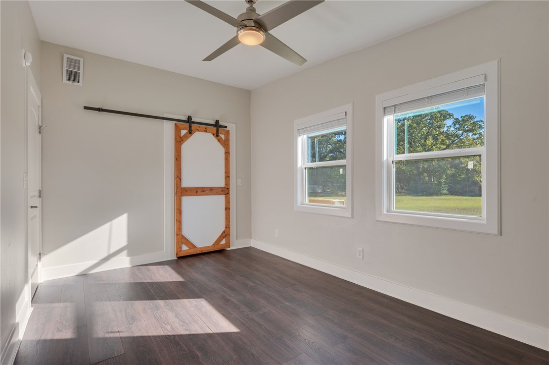 11688 Long Trussel Road Bryan, TX 77808 - Photo 18 of 29 a view of an empty room with wooden floor and a window