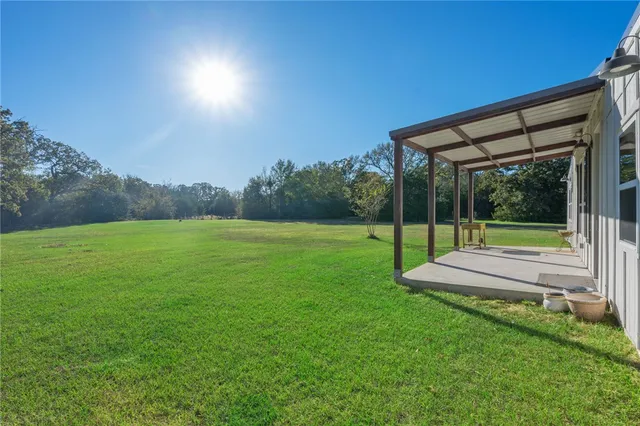 a view of a green field with sitting area