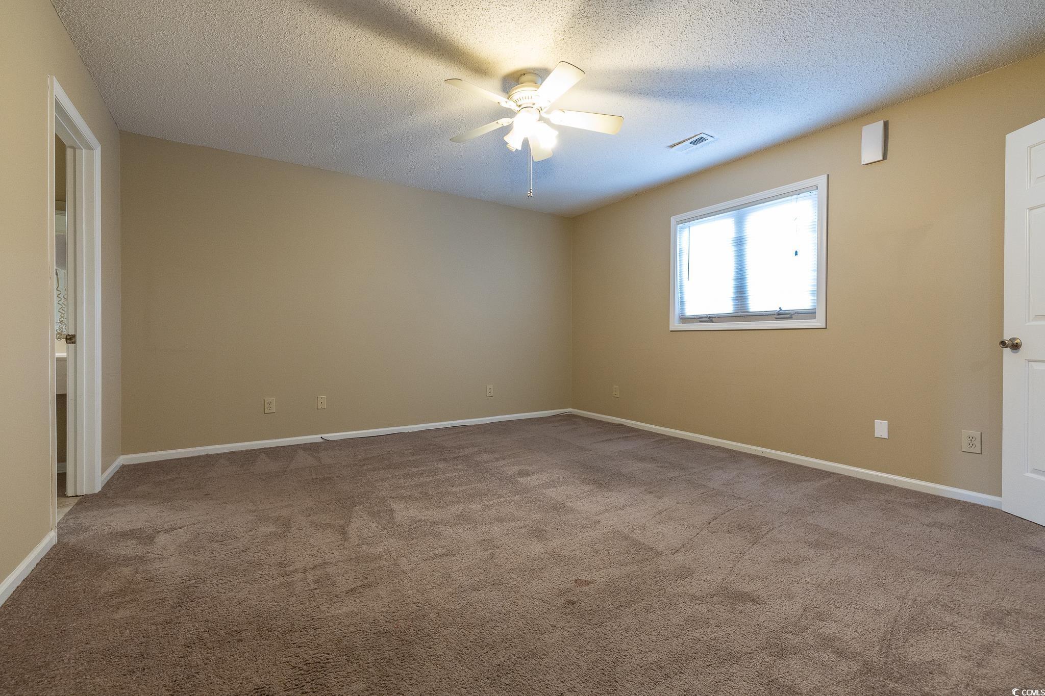 209 Double Eagle Drive, Unit F2 Surfside Beach, SC 29575 - Photo 16 of 17 Unfurnished room featuring light colored carpet, a textured ceiling, and ceiling fan