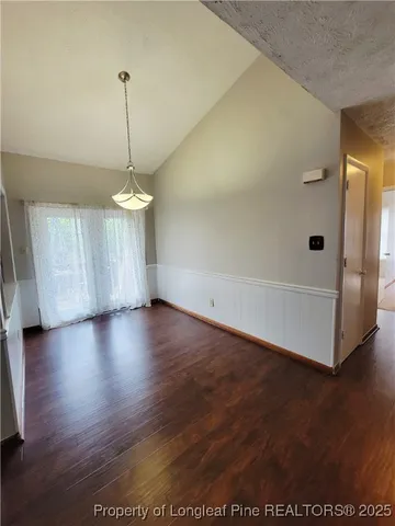 a view of empty room with wooden floor and window