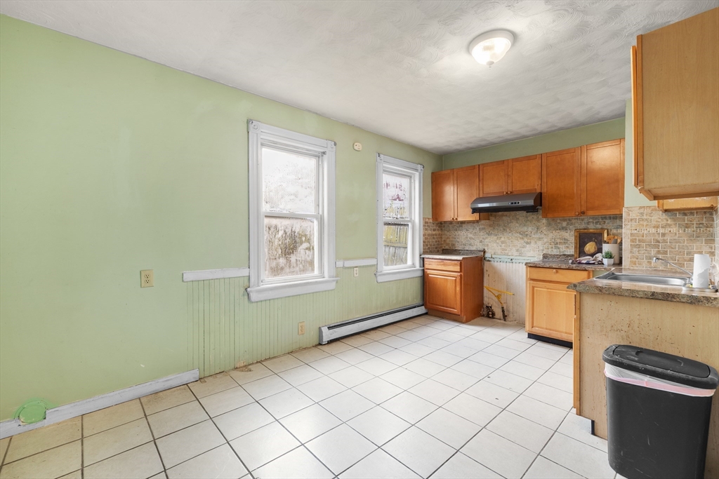 75 Plain Street Lowell, MA 01851 - Photo 2 of 17 a kitchen with a sink cabinets and a window