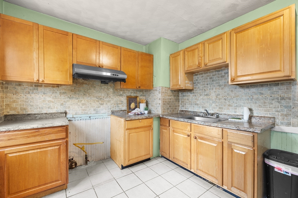 75 Plain Street Lowell, MA 01851 - Photo 3 of 17 a kitchen with a sink stove and cabinets
