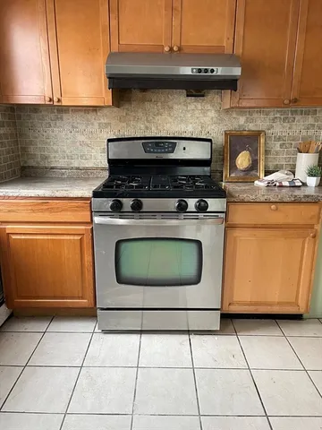 a stove top oven sitting inside of a kitchen