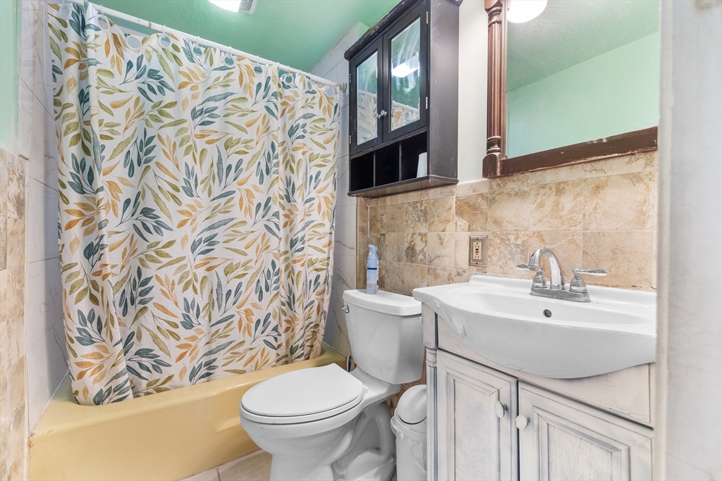 75 Plain Street Lowell, MA 01851 - Photo 9 of 17 a bathroom with a sink and a mirror