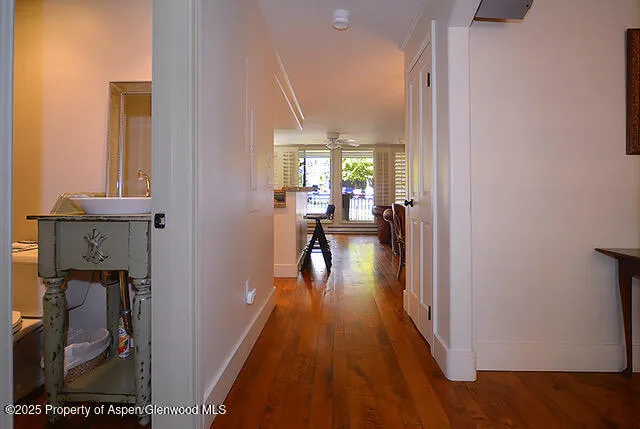 a view of a hallway with wooden floor and furniture