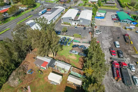an aerial view of residential houses with outdoor space and trees