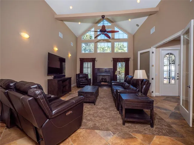 a living room with furniture a chandelier and a flat screen tv
