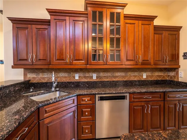 a kitchen with stainless steel appliances granite countertop a sink stove and cabinets