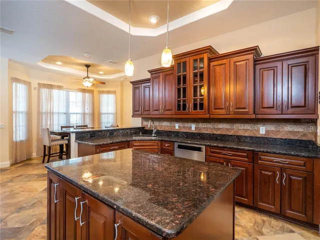 a kitchen with stainless steel appliances granite countertop a sink a stove counter space and cabinets