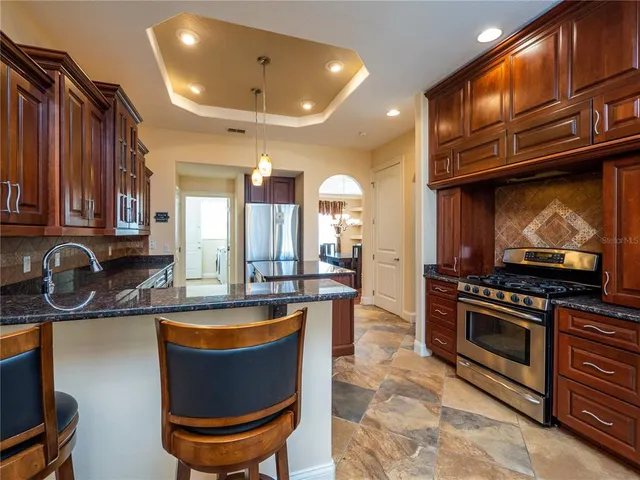 a kitchen with stainless steel appliances granite countertop a stove a sink and a microwave